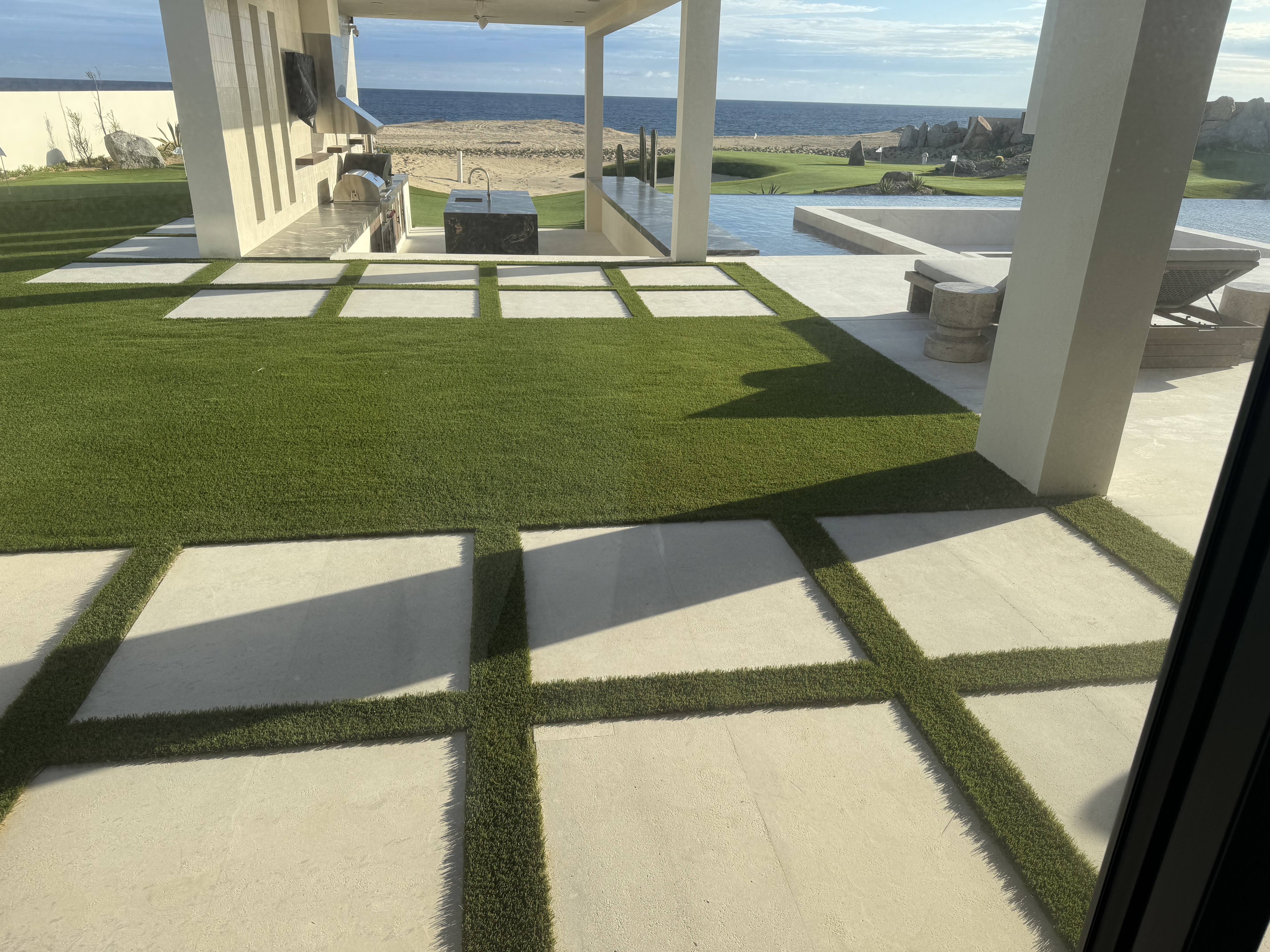 Oceanfront synthetic turf patio with paver inlays