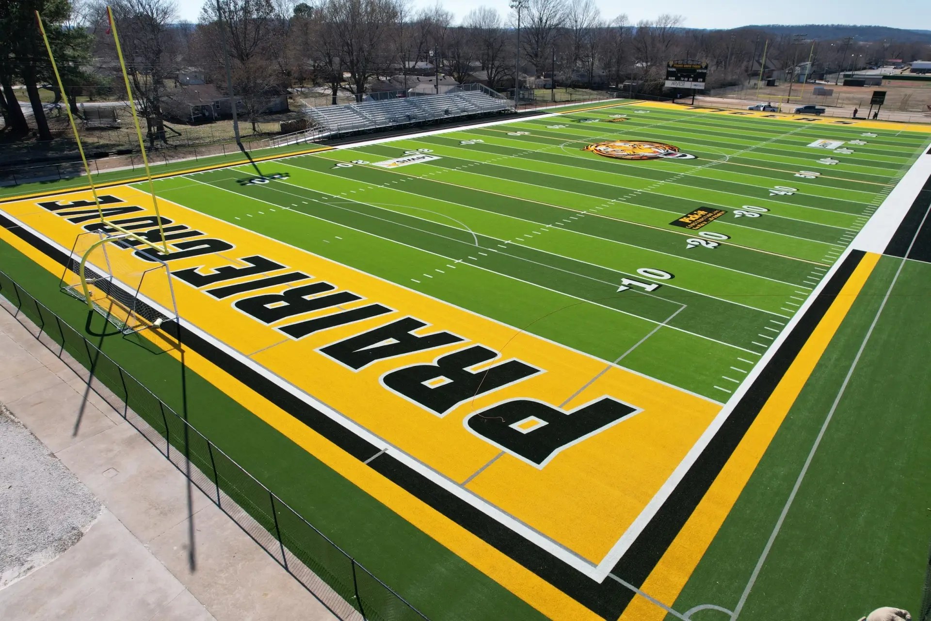Elevated view of a full synthetic-turf football field at a PIVOT reference facility