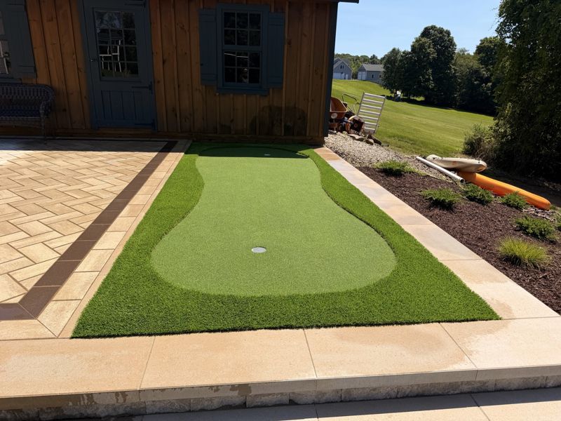 Compact putting strip fitted between a paved terrace and a planted border.