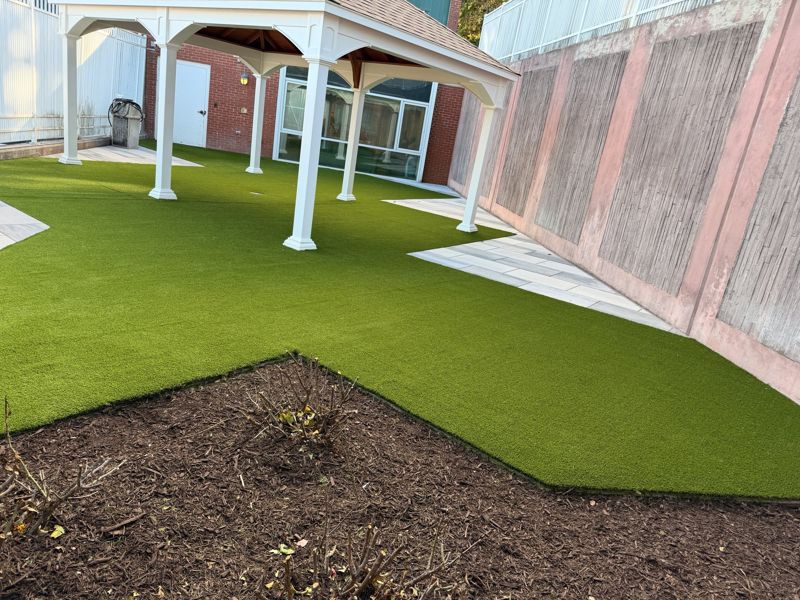 Turf around a covered walkway and landscaped courtyard.